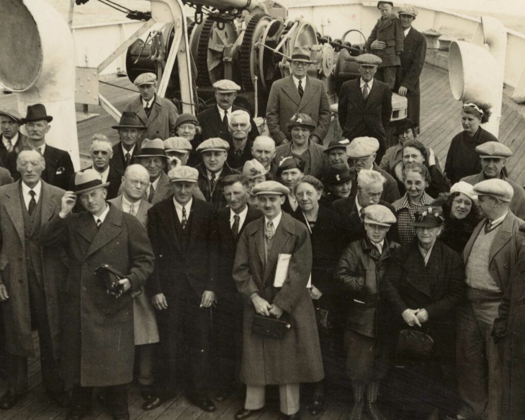 Passengers gathered for a group photograph on the deck of a Norwegian America Line ship.